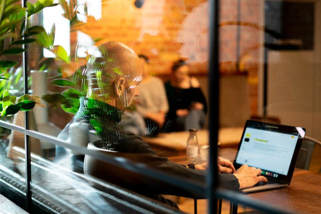 Man typing on laptop in coffee shop