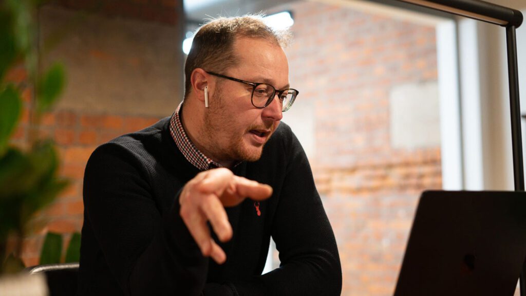 Man talking on a laptop with headphones in