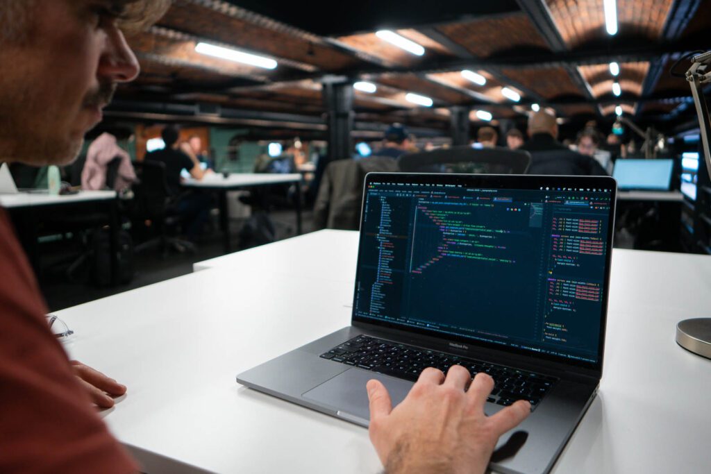 Hand on a laptop keyboard typing code