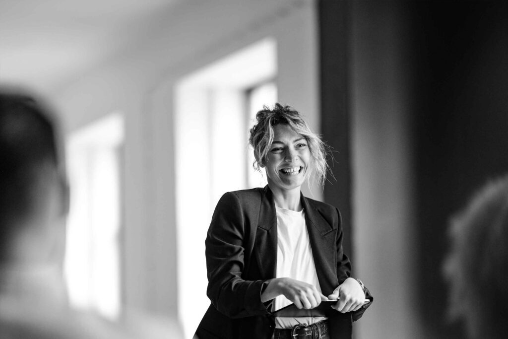 Black and white photo of lady smiling holding a tablet