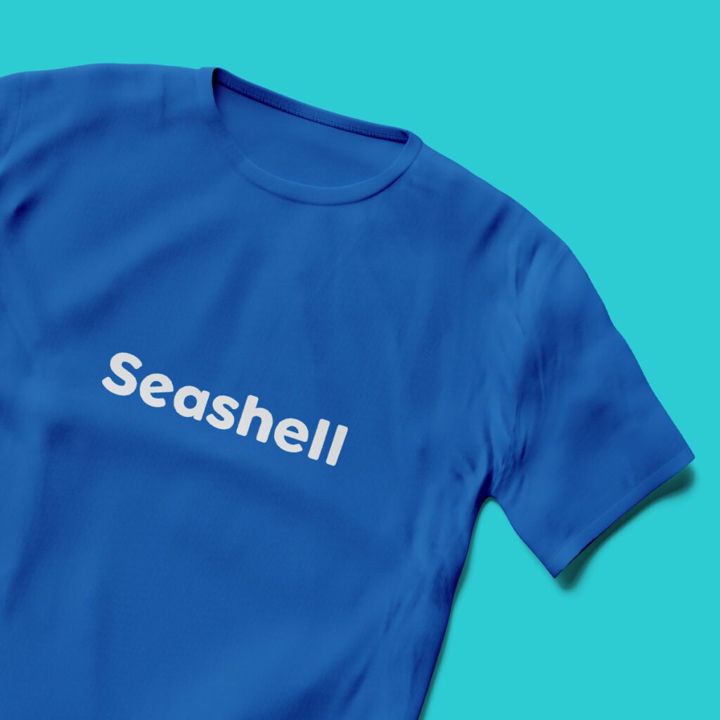 Seashell logo on a blue t-shirt.