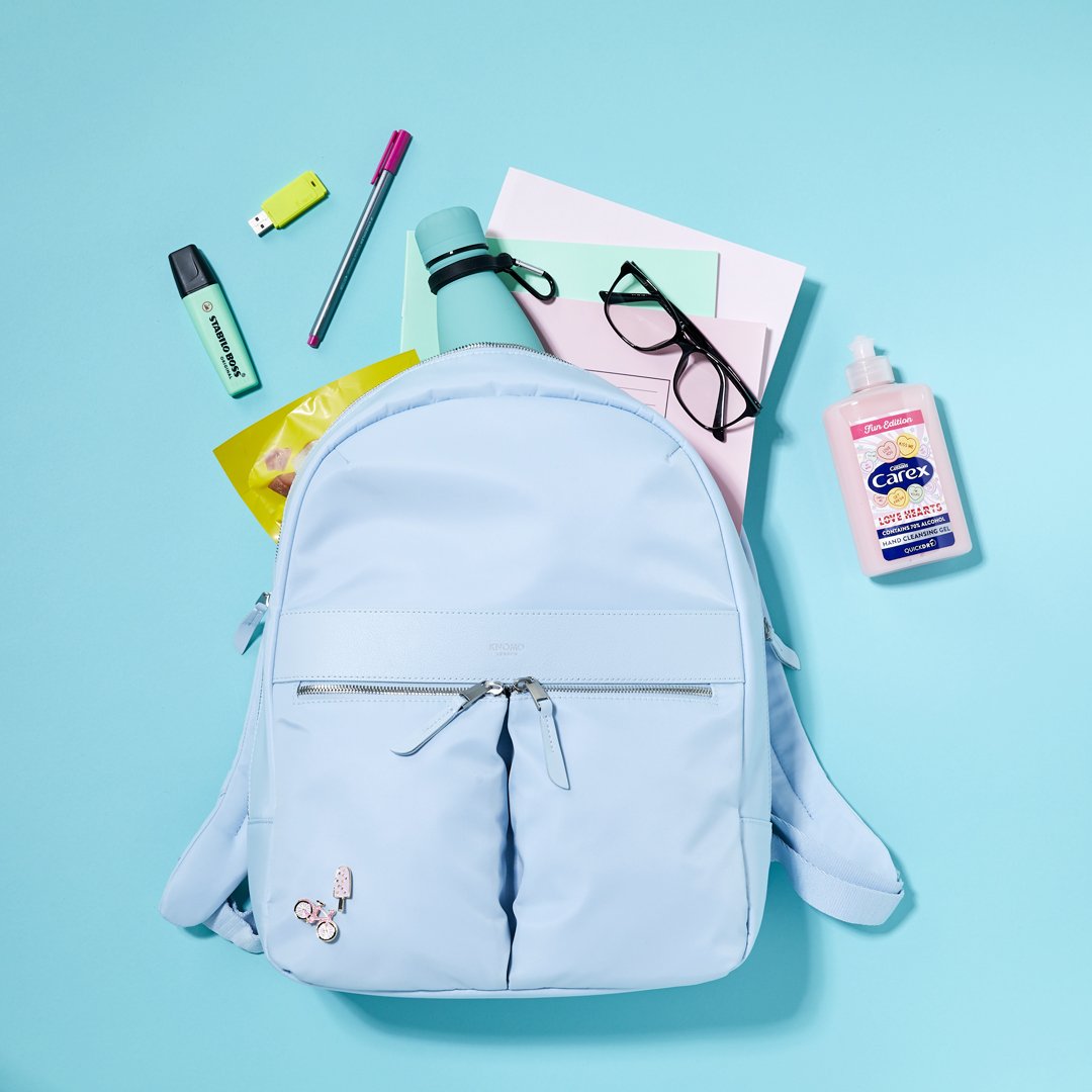 Carex Love Hearts mini hand sanitiser against a school bag and supplies.