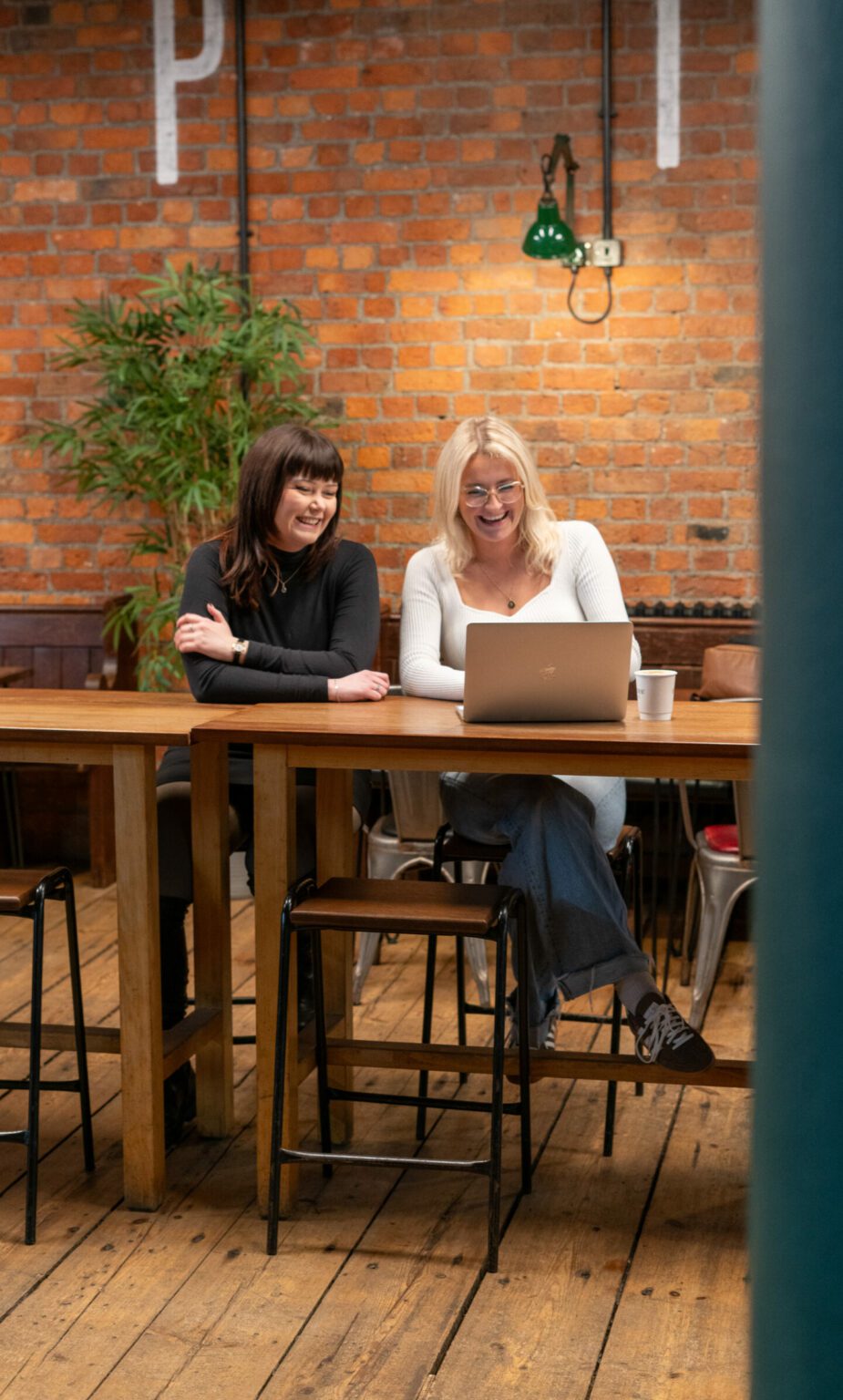 Colleagues smiling over a laptop in a modern office