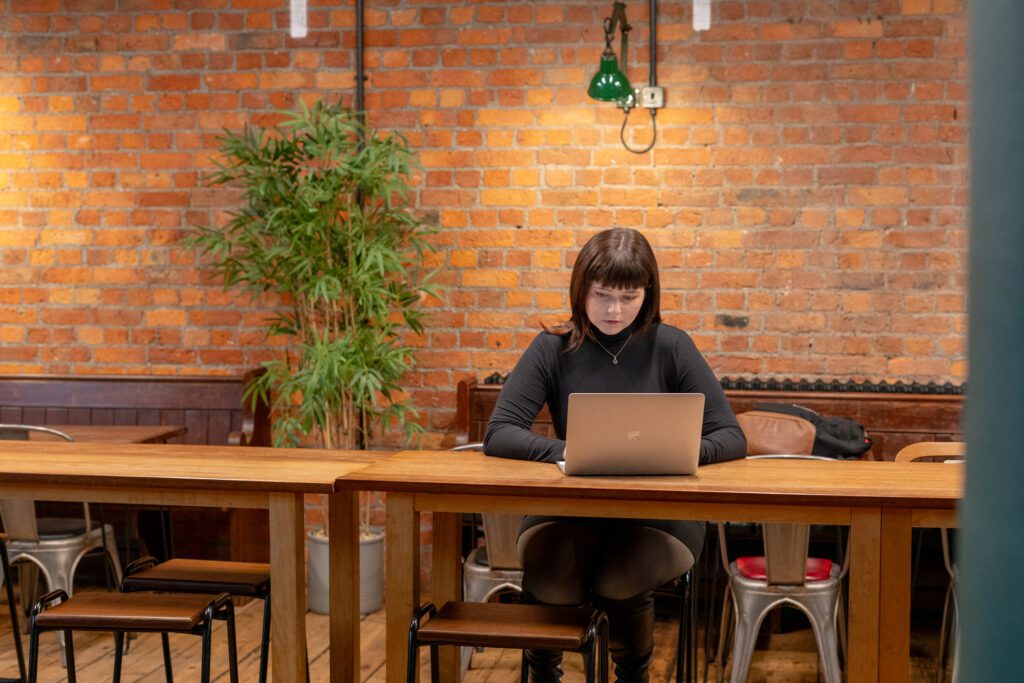 Woman typing on laptop in modern cafe