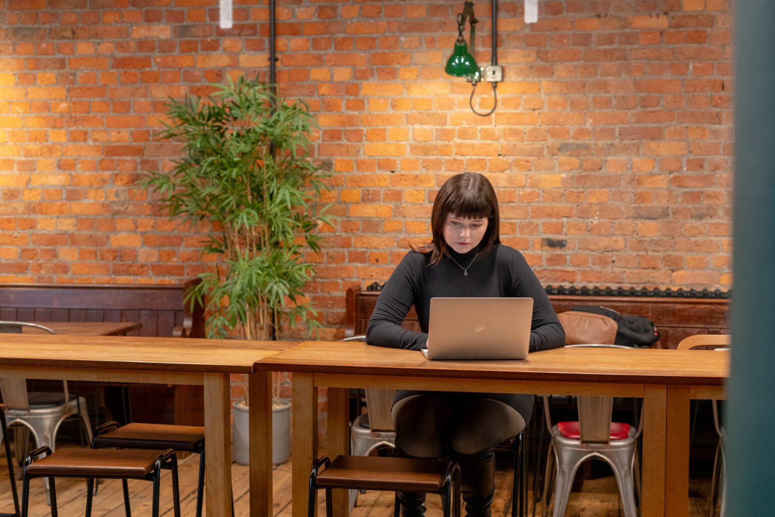 Woman typing on laptop in modern cafe